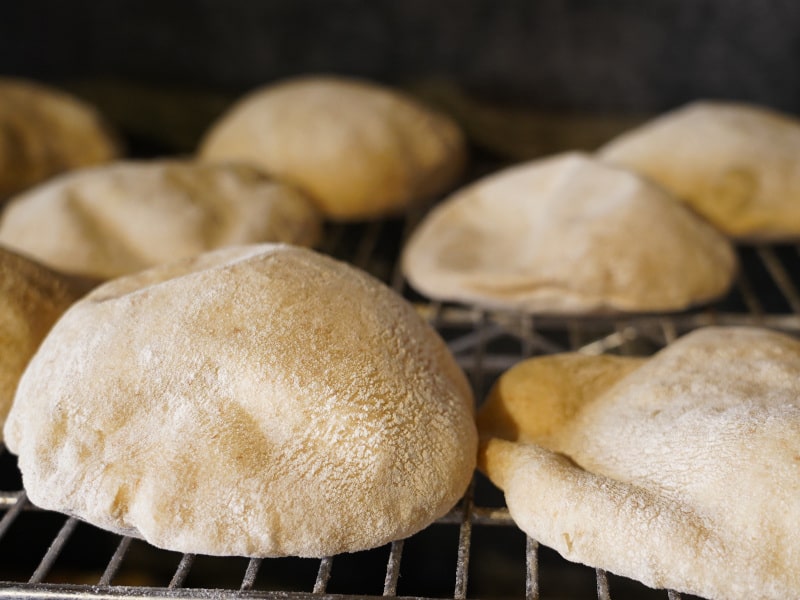 Pita bread baking in an oven